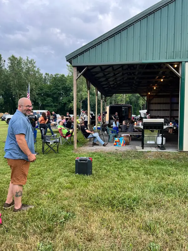 Guests gathered under the green-roofed pavilion during a cookout
