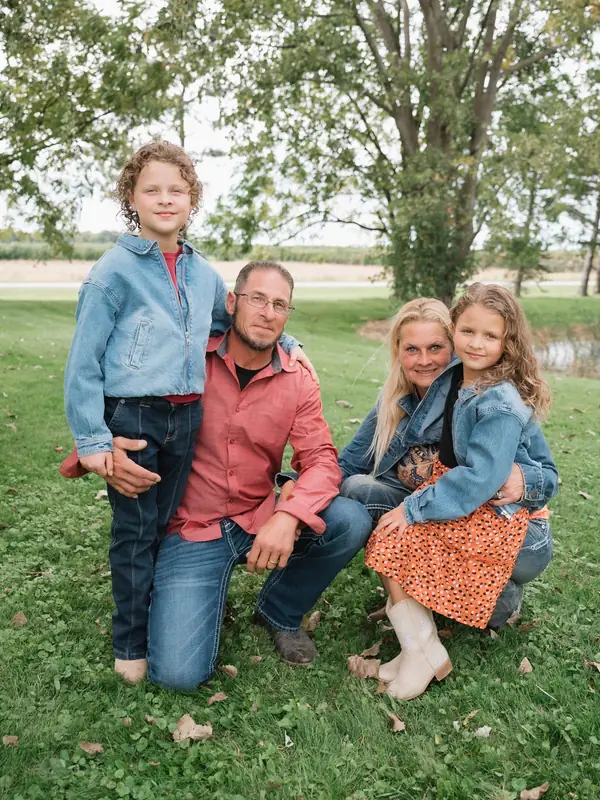 The Wehling family, two adults and two children, outdoors on the ranch lawn